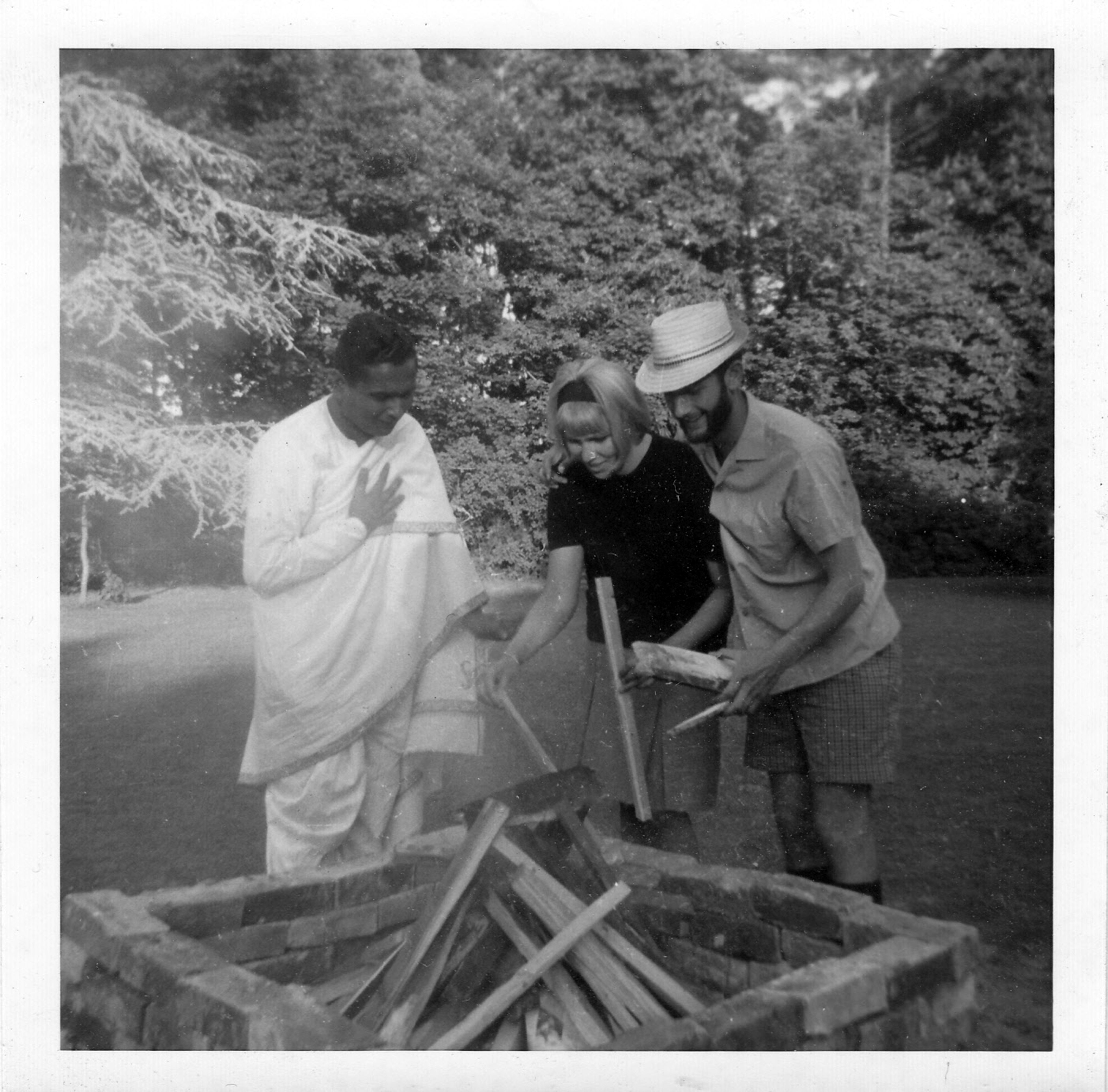 In spring 1963, Engineering student John Earnshaw prepared a fire pit for a barbecue, watched by Patapaditya (Eddie) Pal and friend Ellie Hauser.