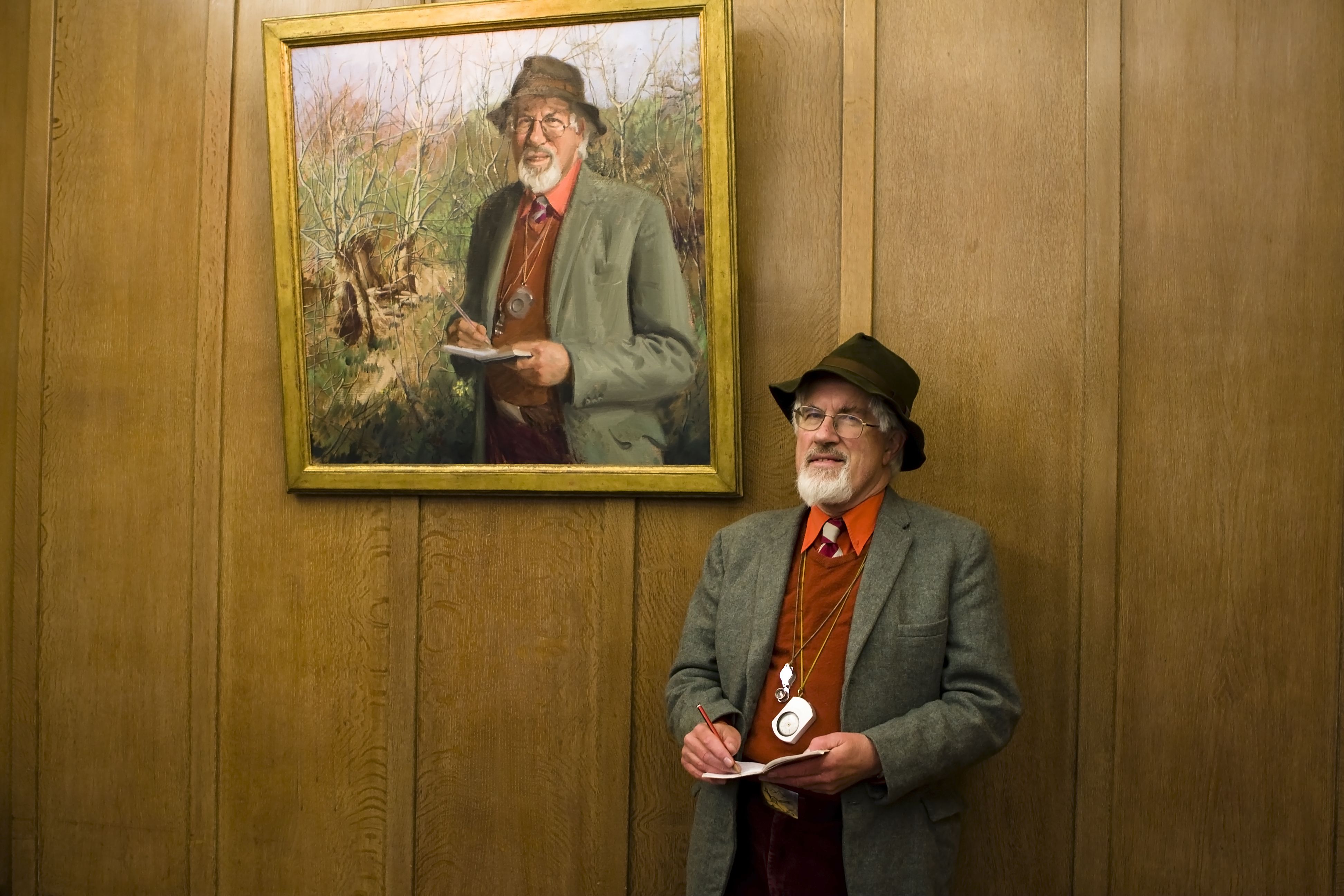 With his portrait, depicting him with his trusty notebook.