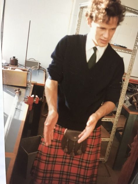 Photo: a bekilted Louis is showing visitors around his lab at the Cavendish.
