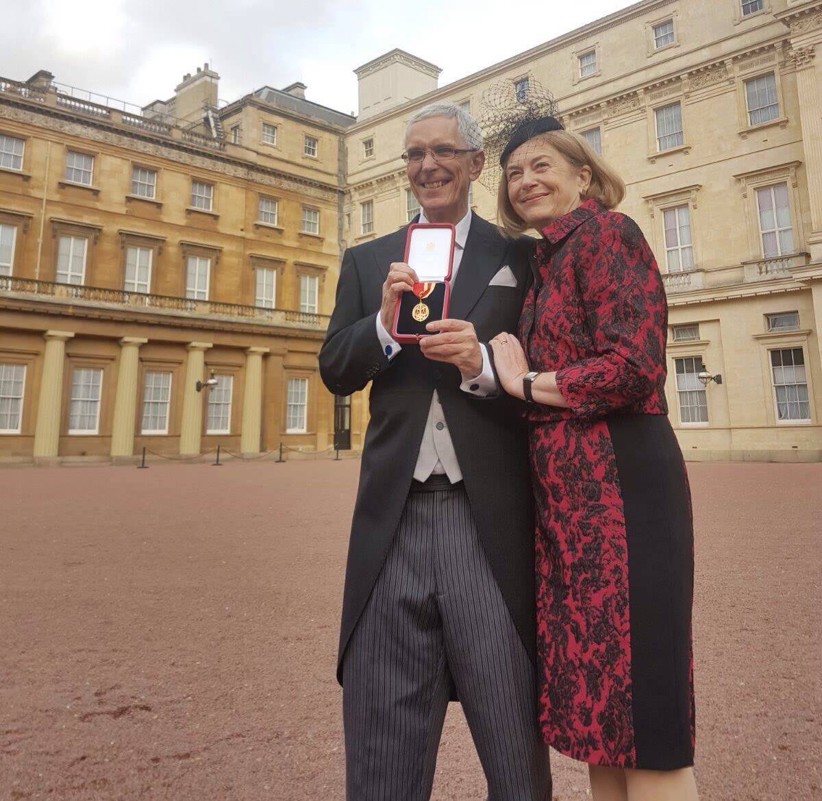 Receiving a knighthood with his wife, Heather